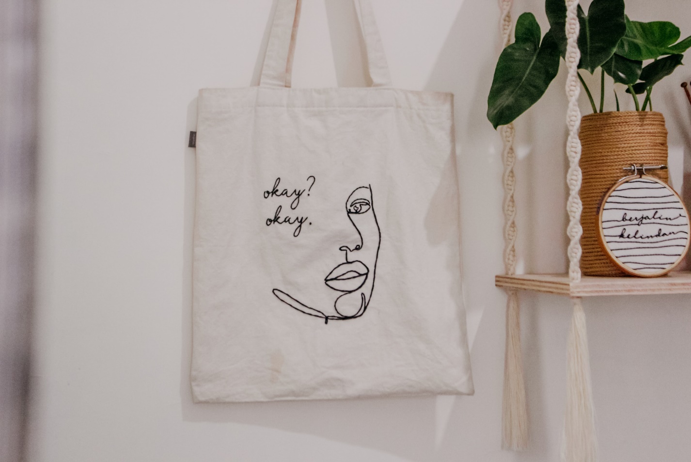 a tote bag beside a plant