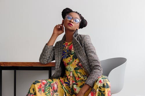 A woman wearing a floral dress with a striped blazer