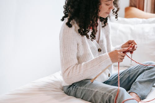 A woman crocheting with yarn