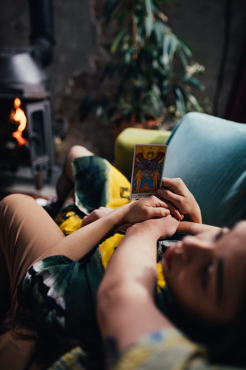 A woman holding a tarot card 