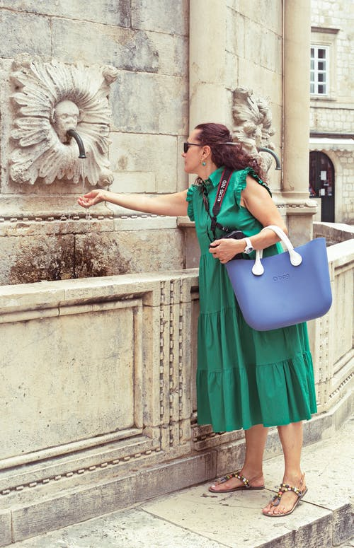 female tourist in green dress with blue tote bag 