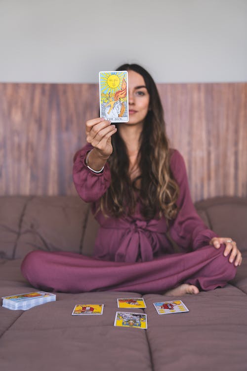 A woman holding a tarot card 